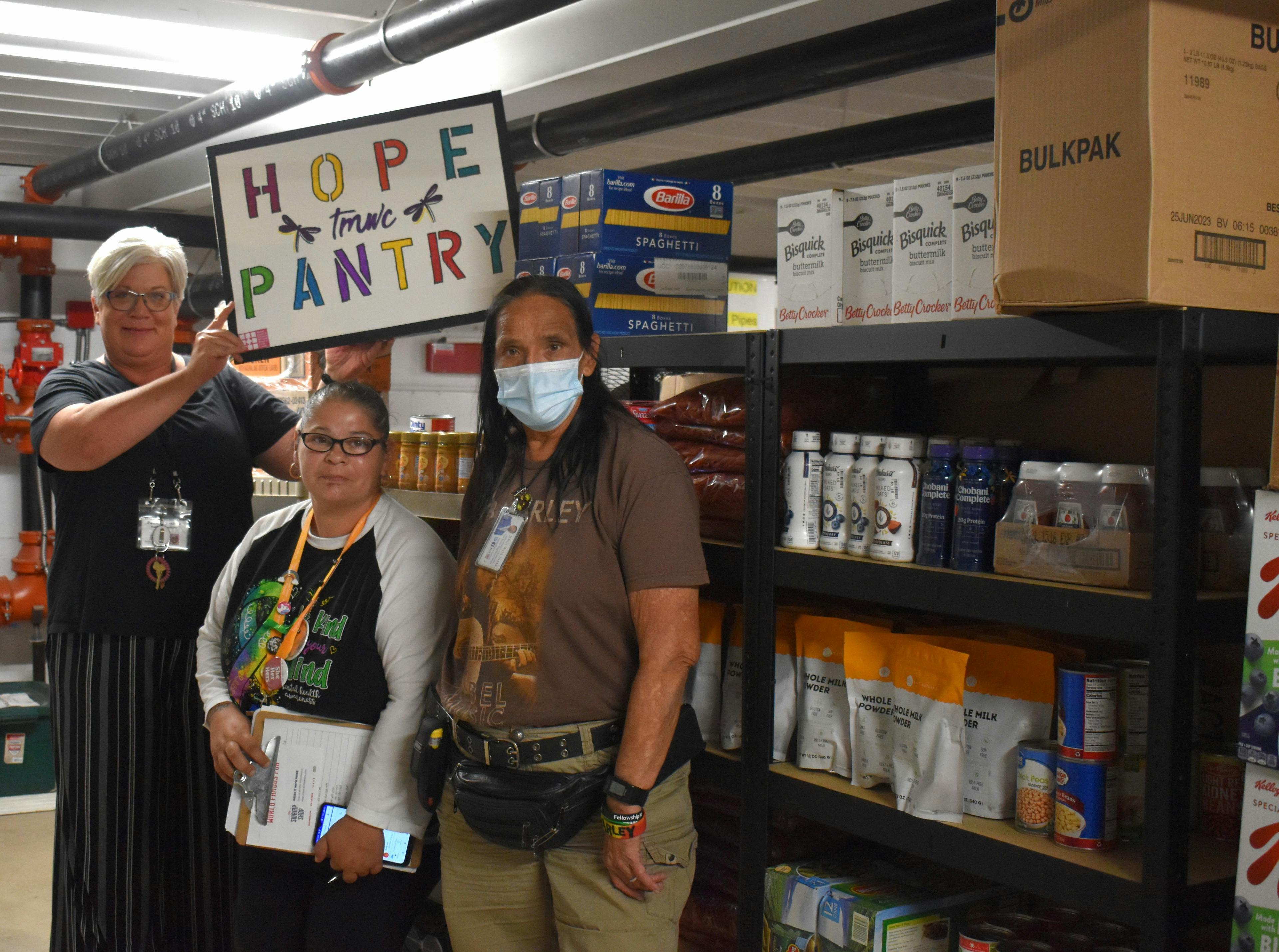Helping Other People (HOPE) Eat volunteers stand in front of a food pantry